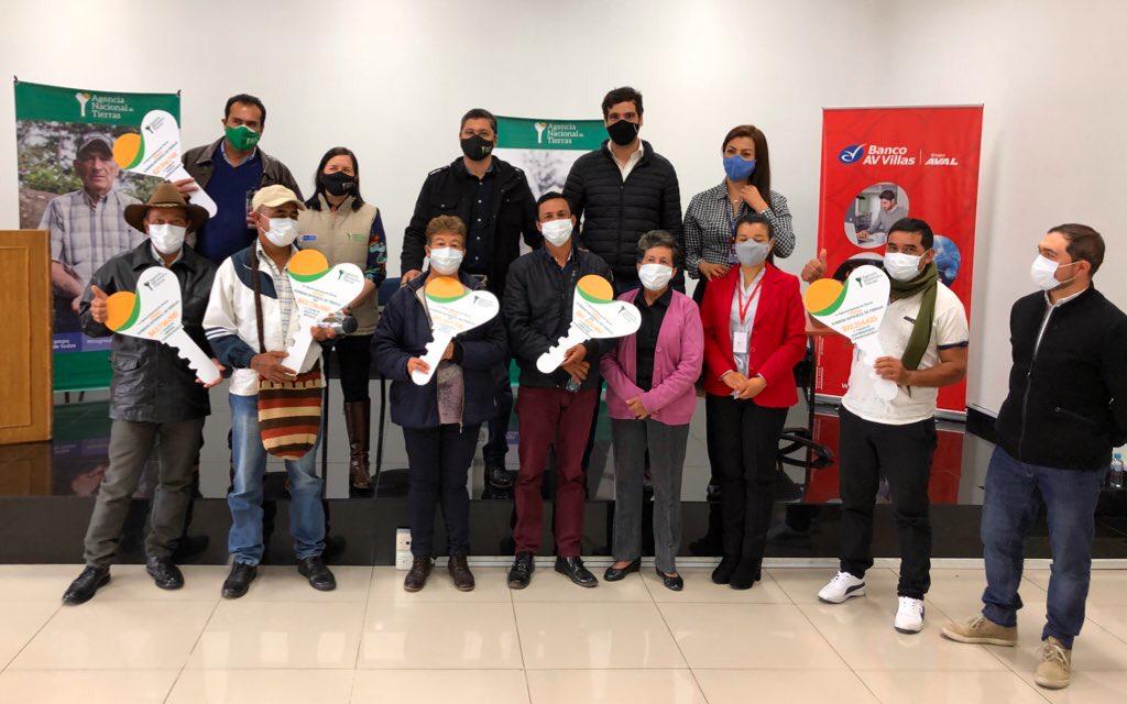 Grupo de campesinos posan mostrando los recursos para implementar sus proyectos con los agentes de la ANT 