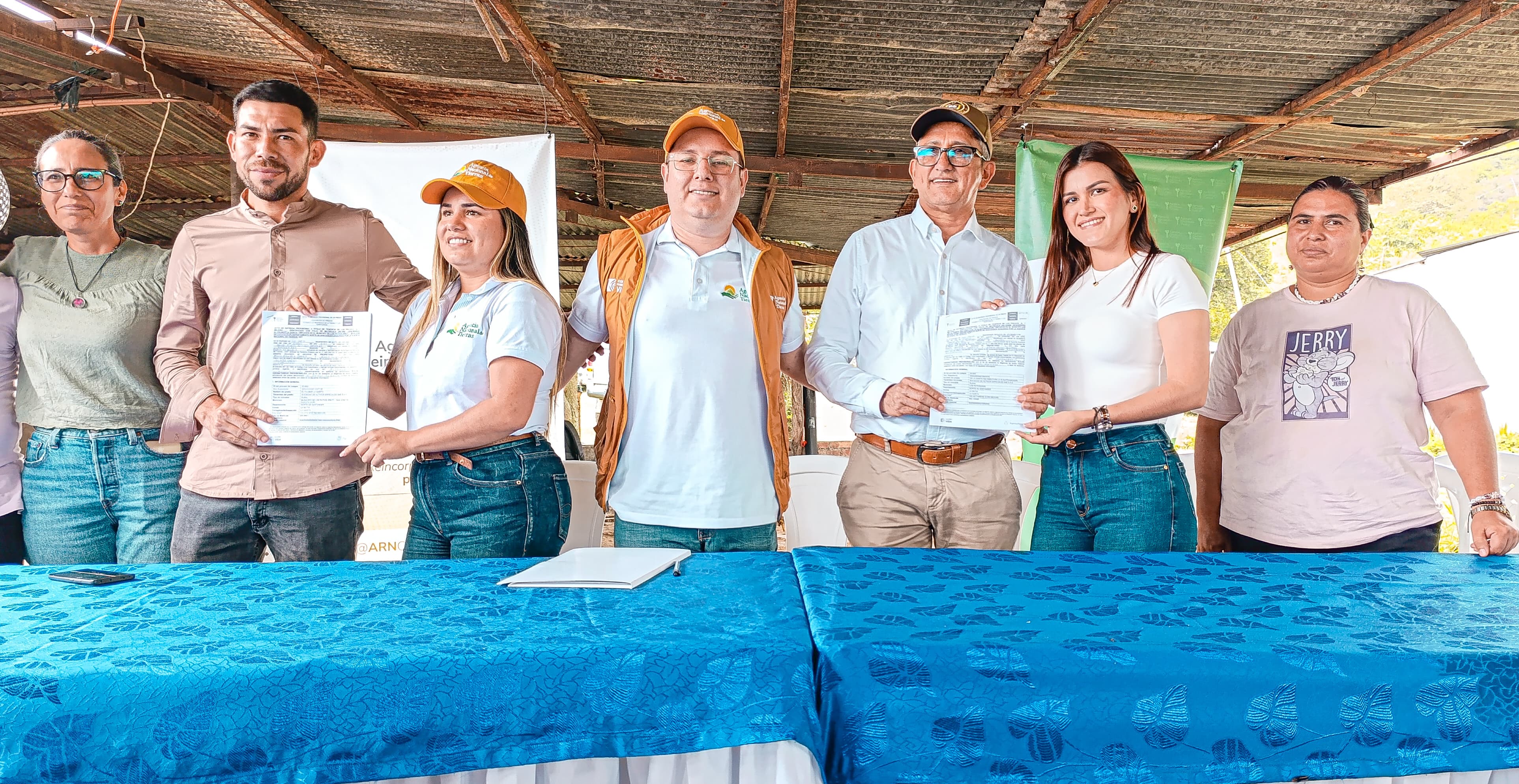 n-grupo-de-personas-de-pie-alrededor-de-una-mesa-recibiendo-documentos-de-tierras-entregadas