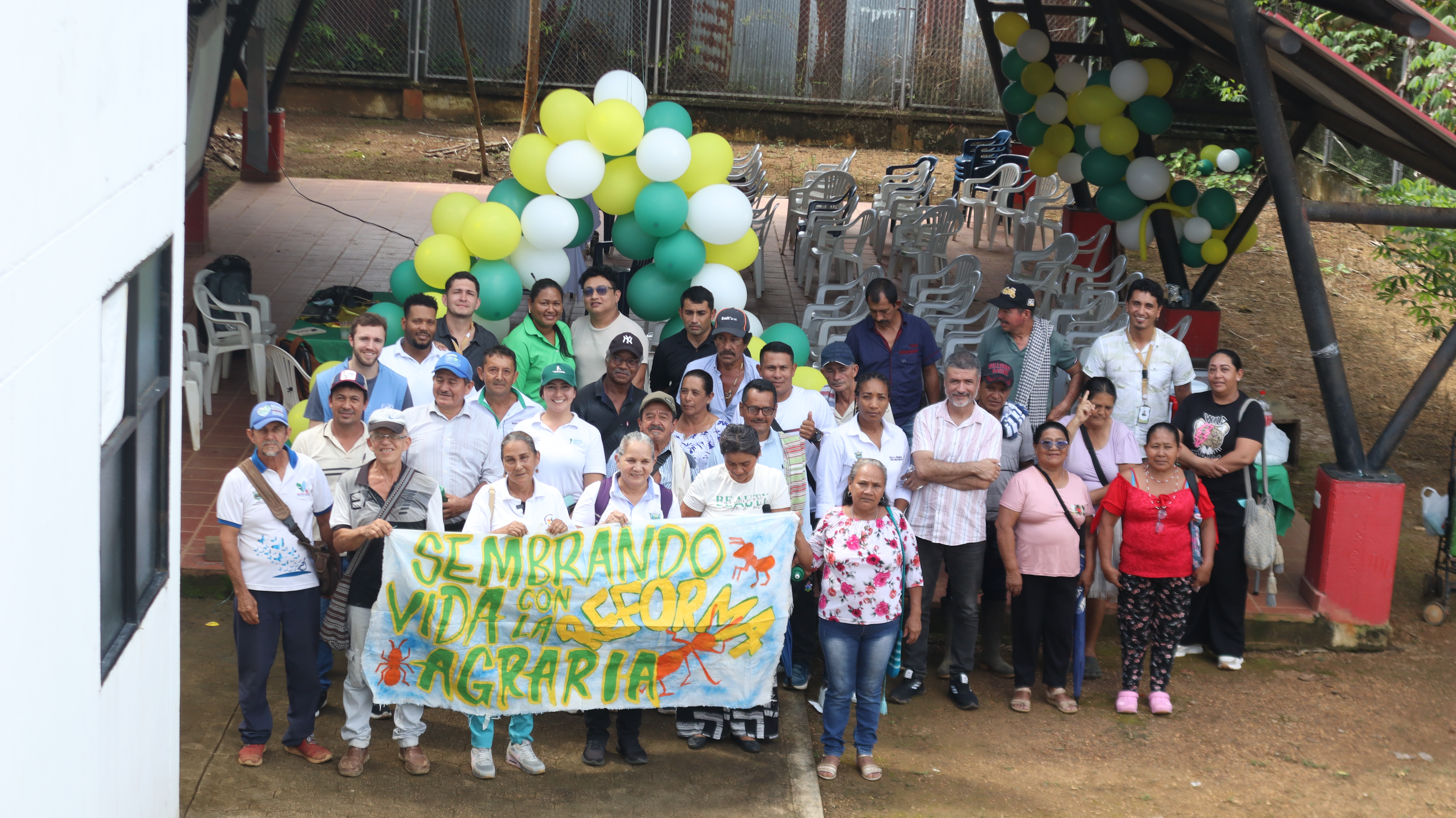 un-grupo-de-personas-parados-frente-a-un-edificio-que-sostiene-globos