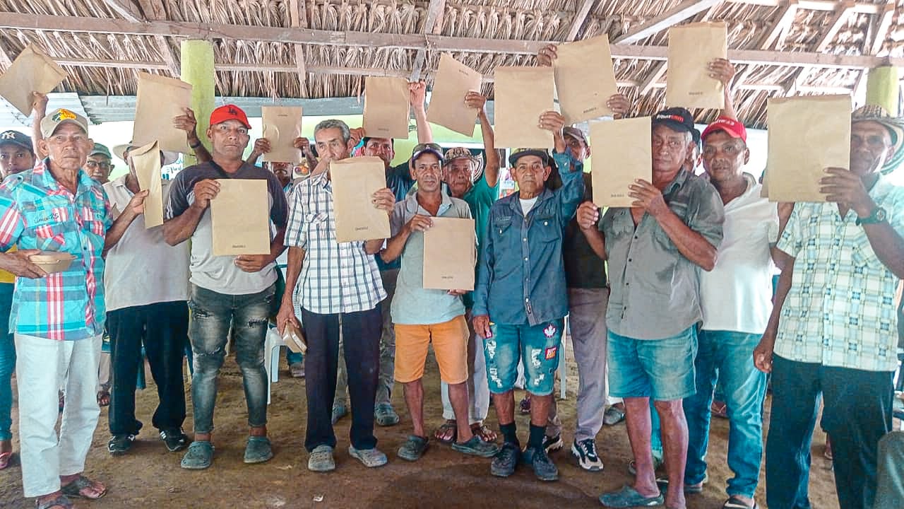 un-grupo-de-personas-que-sostienen-documentos-en-una-choza
