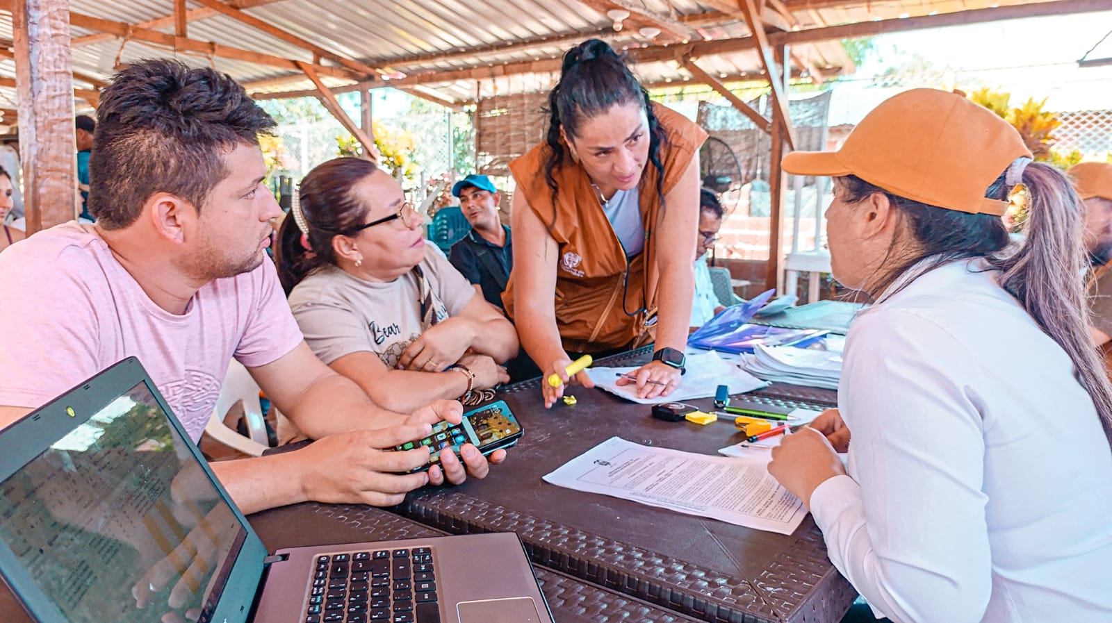 un-grupo-de-personas-sentadas-alrededor-de-una-mesa-con-computadoras