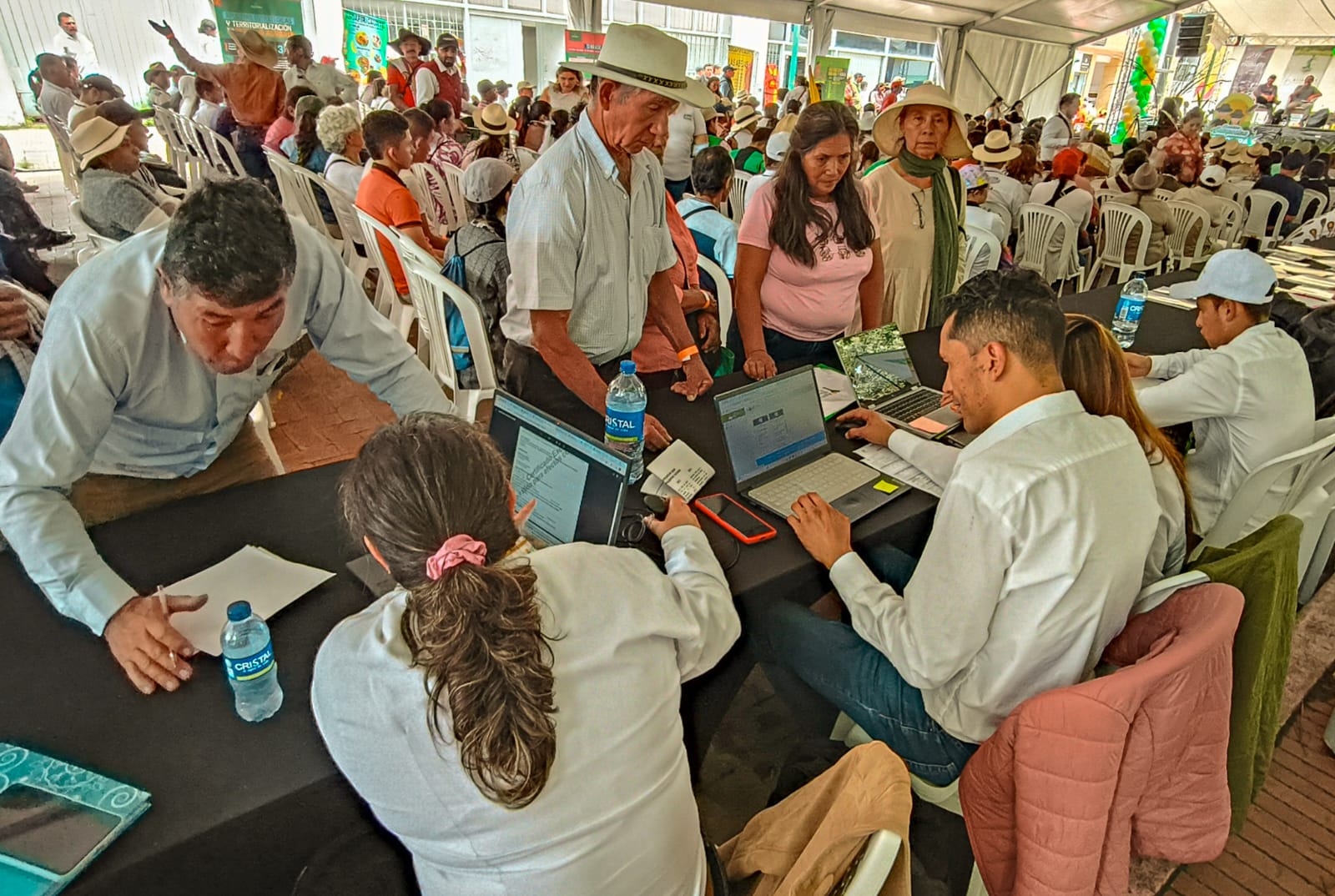gente-sentada-en-mesas-con-computadoras-porttiles-y-papeles
