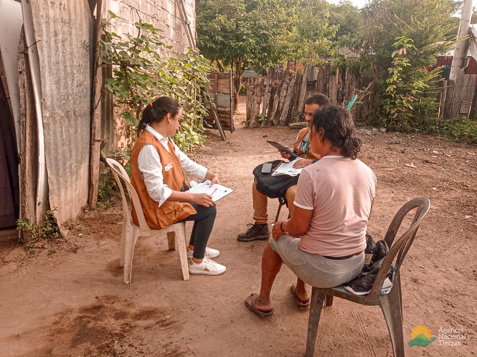 tres-personas-sentadas-en-sillas-en-un-rea-de-tierra