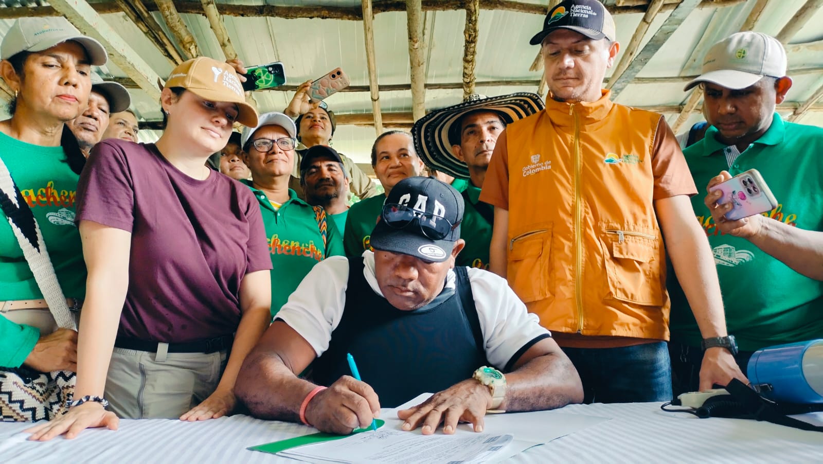 un-grupo-de-personas-parados-alrededor-de-una-mesa-firmando-papeles