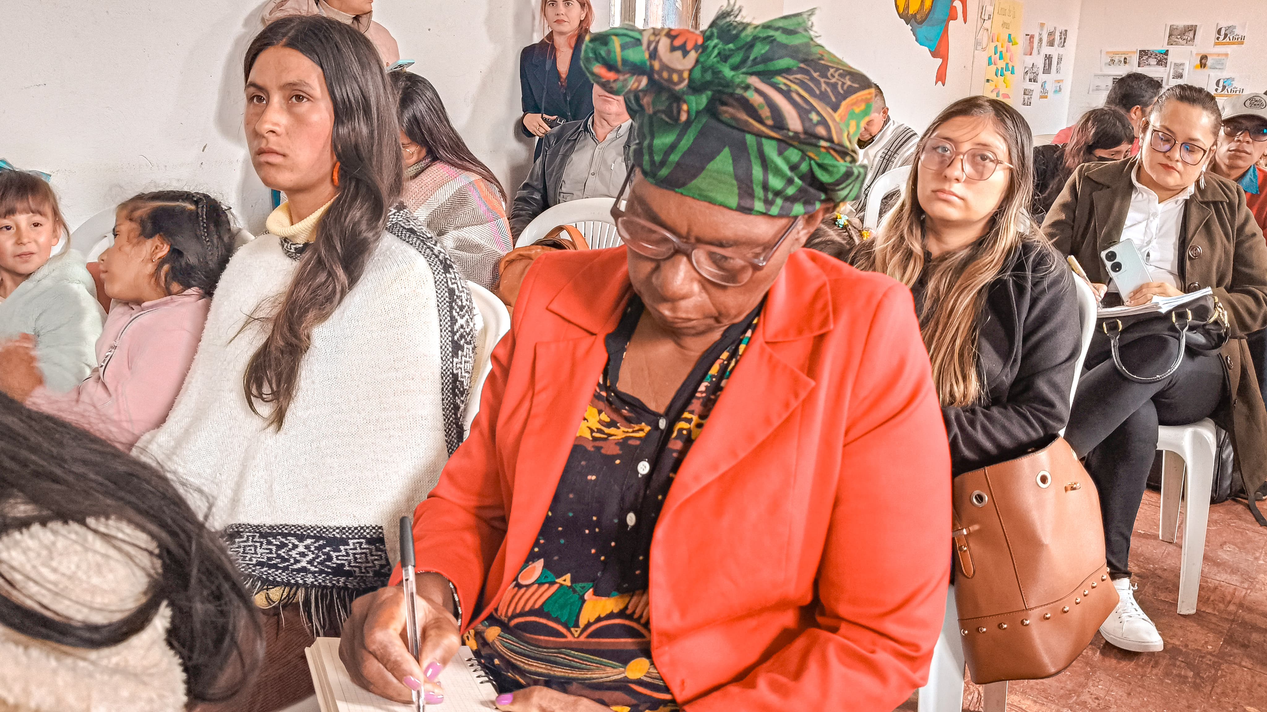 una-mujer-sentada-en-una-silla-con-un-grupo-de-personas