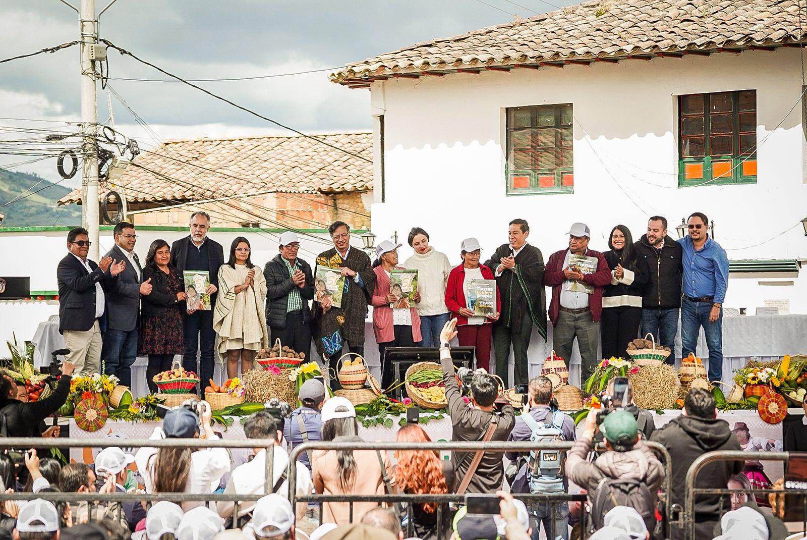 Nombre un-grupo-de-personas-parados-en-un-escenario-con-titulos-de-propiedad-en-las-manos