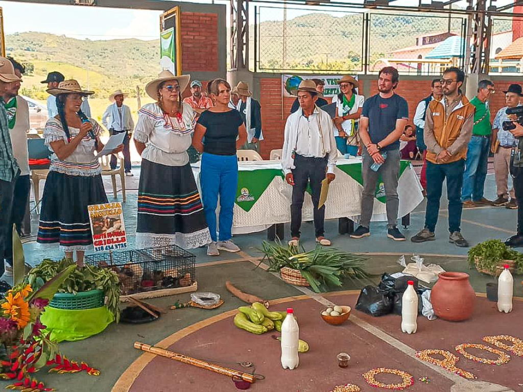 un-grupo-de-personas-de-pie-alrededor-de-un-crculo-con-flores-y-verduras