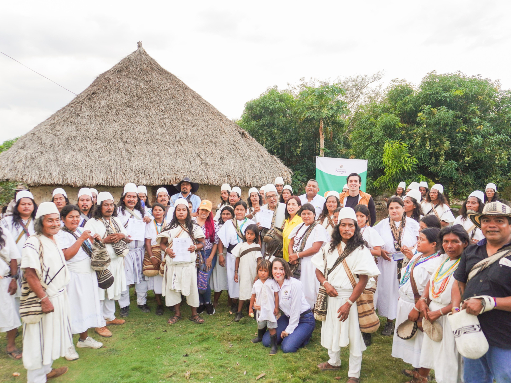 un-grupo-de-personas-en-blanco-de-pie-frente-a-una-cabana