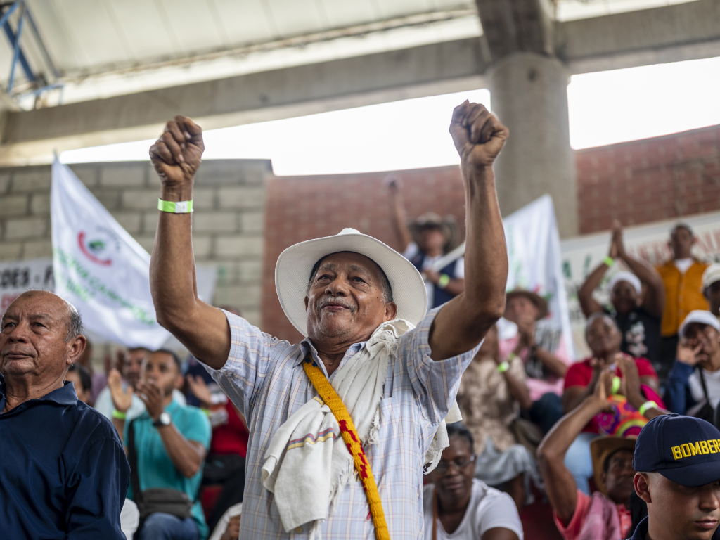 un-hombre-con-un-sombrero-blanco-y-una-camisa-blanca-se-levanta-las-ma