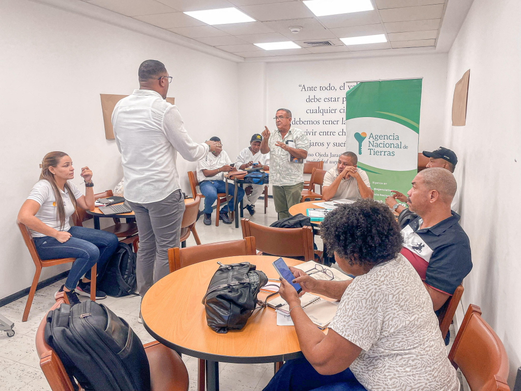 un-grupo-de-personas-sentadas-alrededor-de-las-mesas-en-una-habitacion