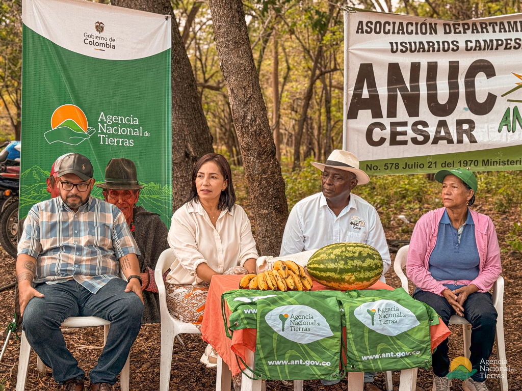 un-grupo-de-personas-sentadas-alrededor-de-una-mesa-con-un-banner