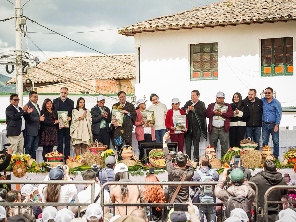 Nombre un-grupo-de-personas-parados-en-un-escenario-con-titulos-de-propiedad-en-las-manos