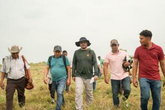 Grupo de varios hombres caminando sobre un predio.