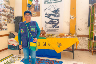 mujer-sonriendo-al-lado-de-una-mesa-con-productos-del-mercado-campesino