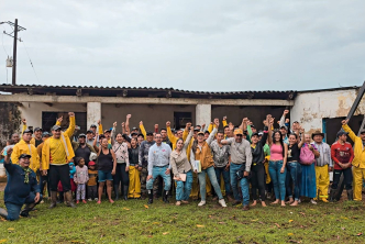 un-grupo-de-personas-en-chaquetas-amarillas-paradas-frente-a-un-edificio