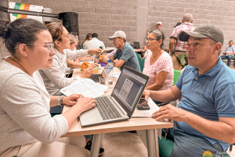un-grupo-de-personas-sentadas-en-una-mesa-con-computadoras-portatiles