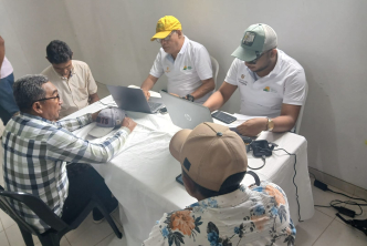un-grupo-de-personas-sentadas-en-una-mesa-con-computadoras-portatiles