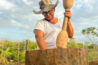una-mujer-con-un-sombrero-sostiene-un-palo-de-madera