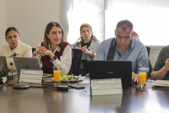 un-grupo-de-personas-sentadas-en-una-mesa-con-computadoras-portatiles