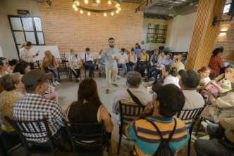 un-grupo-de-personas-sentadas-en-sillas-en-una-habitacion