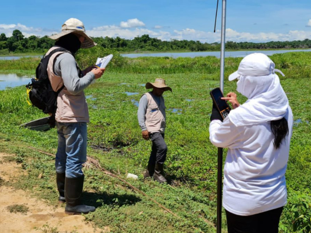 Personas estudiando un terreno de zona verde en la ciénaga el Garzal.