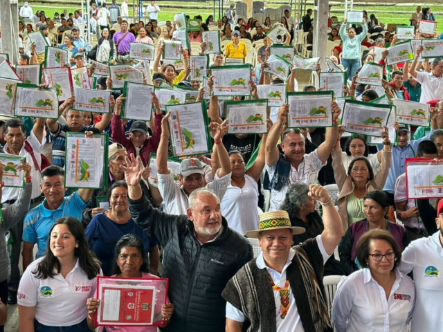 Familias campesinas sosteniendo sus títulos y miembros de la ANT en Cauca.