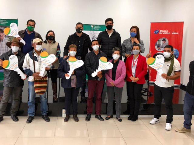 Grupo de campesinos posan mostrando los recursos para implementar sus proyectos con los agentes de la ANT 