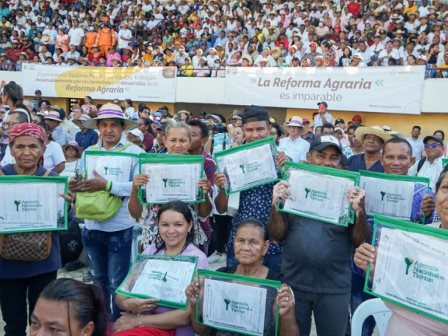 Campesinos sosteniendo sus títulos celebrando en el Coliseo de Ferias de Sincelejo (Sucre).