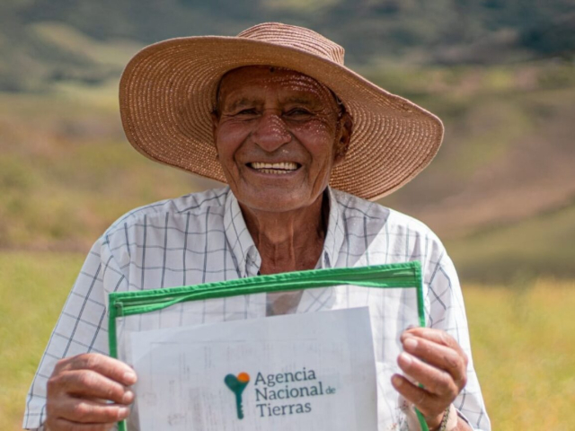 Señor campesino sonriendo recibiendo su título.