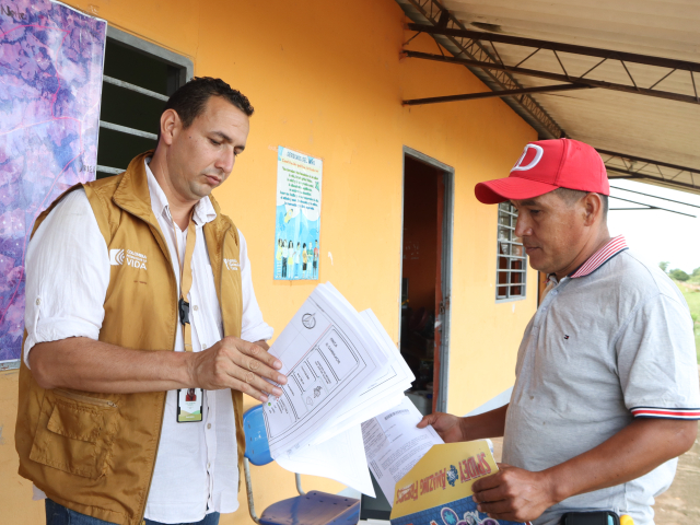 dos-hombres-parados-frente-a-un-edificio-que-sostiene-papeles