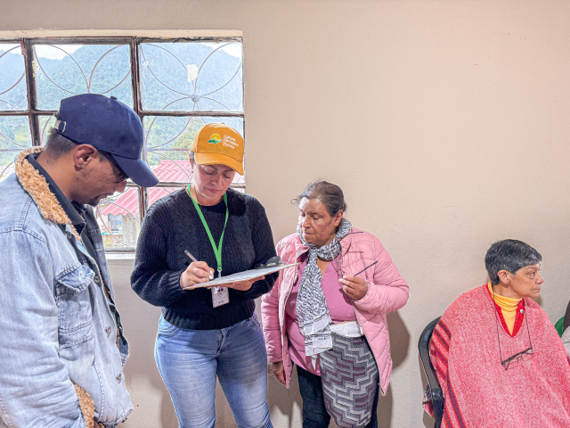 un-grupo-de-personas-de-pie-alrededor-de-una-mesa-con-un-portapapeles