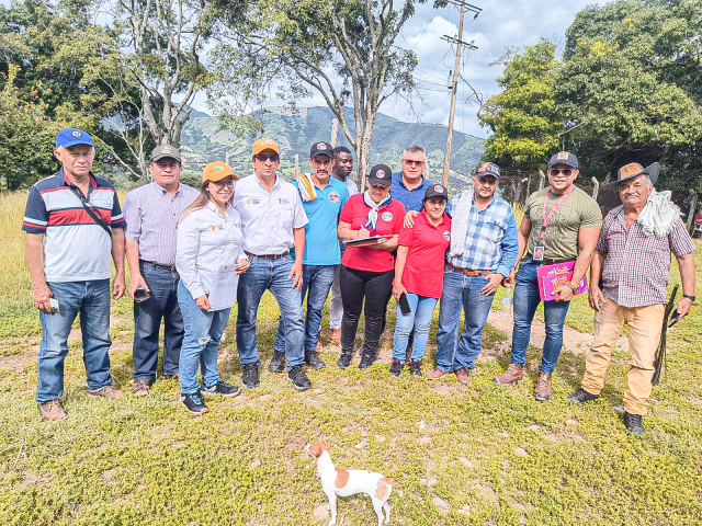 un-grupo-de-personas-parados-en-un-campo-con-un-perro