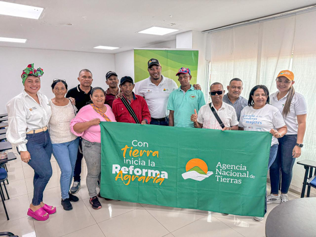 un-grupo-de-personas-parados-frente-a-un-banner-de-la-reforma-agraria