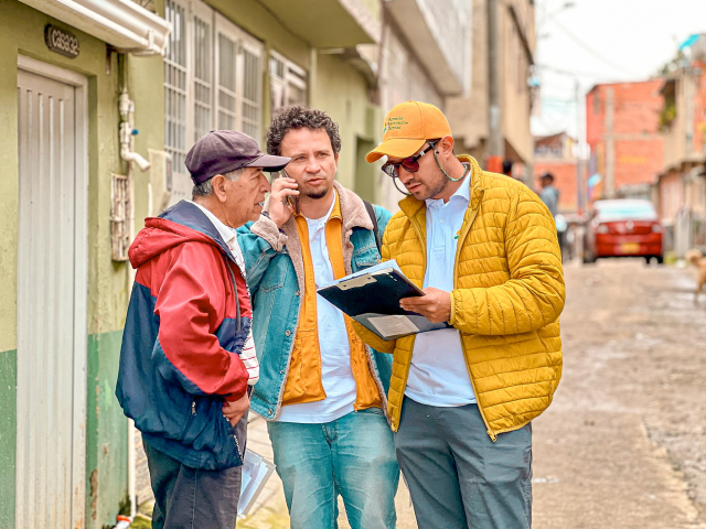 tres-hombres-parados-en-la-calle-mirando-un-portapapeles