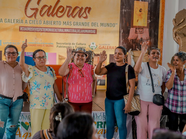 un-grupo-de-mujeres-parados-frente-a-un-banner