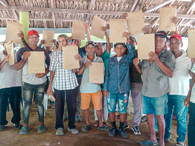 un-grupo-de-personas-que-sostienen-documentos-en-una-choza