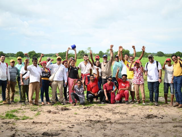 un-grupo-de-personas-parados-en-un-campo-con-las-manos-en-alto