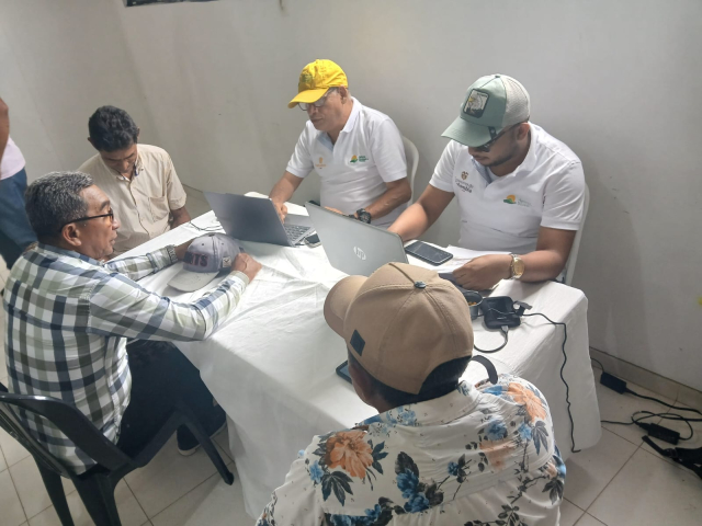 un-grupo-de-personas-sentadas-en-una-mesa-con-computadoras-portatiles