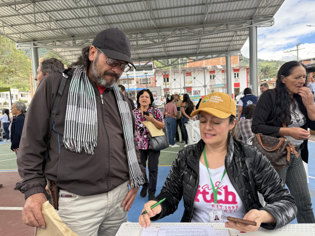 un-hombre-y-una-mujer-firmando-papeles-en-una-mesa