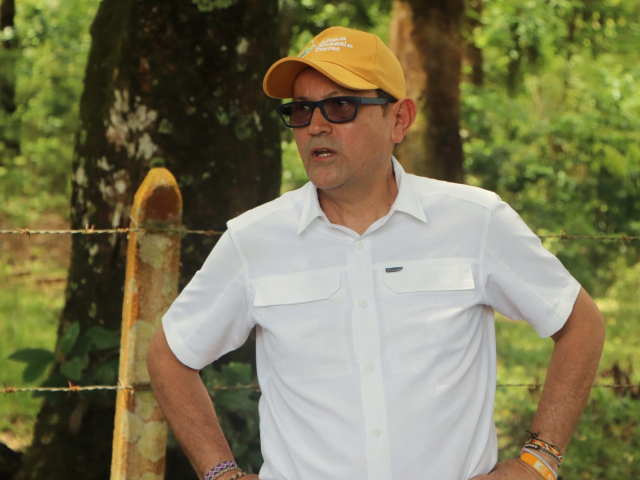 un-hombre-con-camisa-blanca-y-sombrero-amarillo-parado