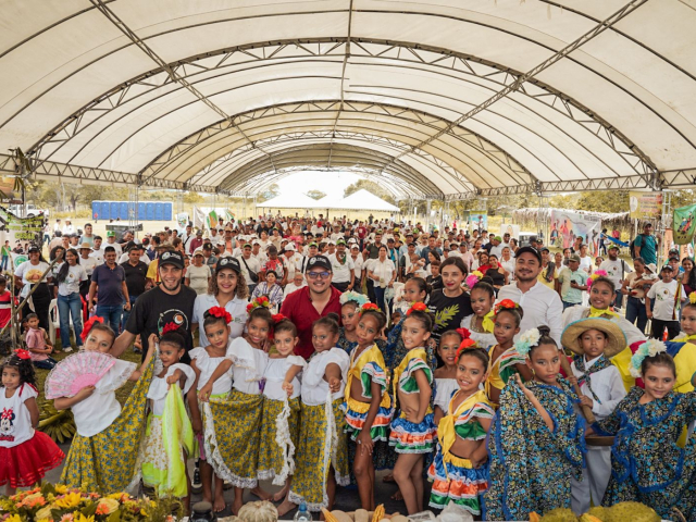 un-grupo-de-personas-vestidas-de-colores-de-pie-en-un-polideportivo
