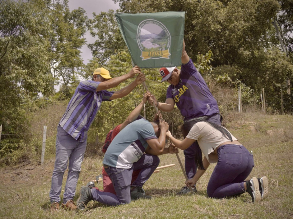 Campesinos sembrando simbolicamente una bandera de una asociación.