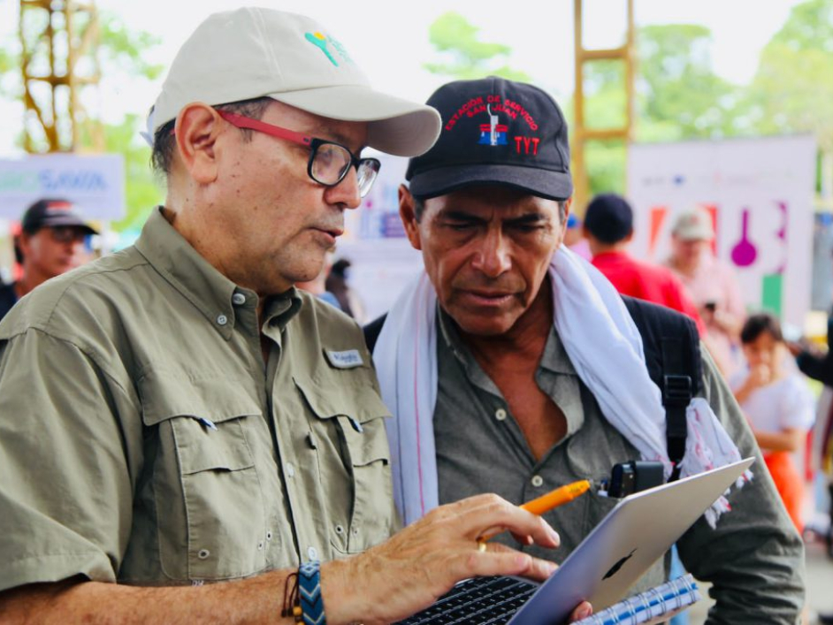 Dos señores hablando y revisando un documento.
