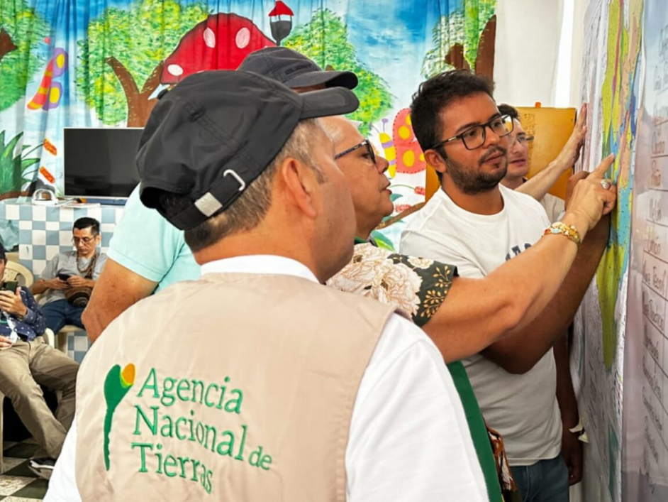 Funcionarios de la Agencia Nacional de Tierras y funcionarios de alcaldías municipales de Paicol y El Agrado en el Huila revisando el mapa.