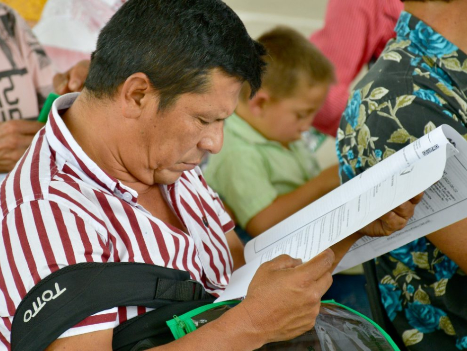 Campesino revisando el título entregado.