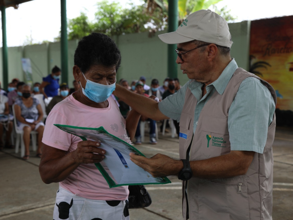 Campesina de monteria recibiendo título de propiedad por parte de funcionario 