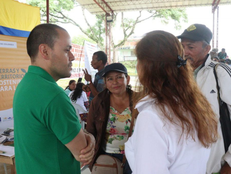 Tres personas conversando en la feria de servicios institucionales de la Zona de Reserva Campesina Pato-Balsillas
