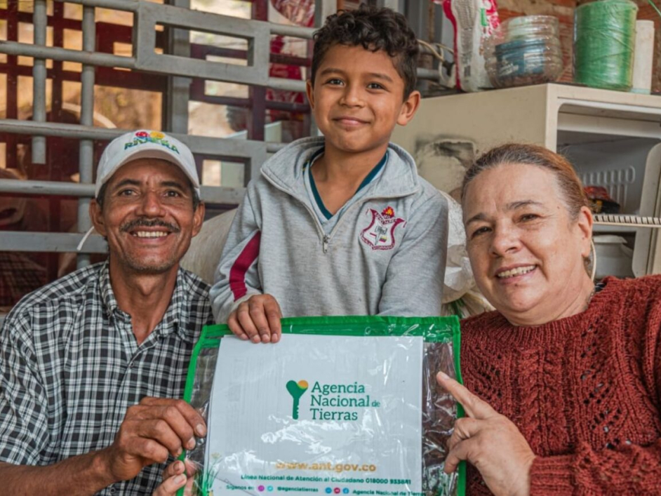 Familia campesina con el título de su predio, entregado por la ANT en San Vicente del Caguán