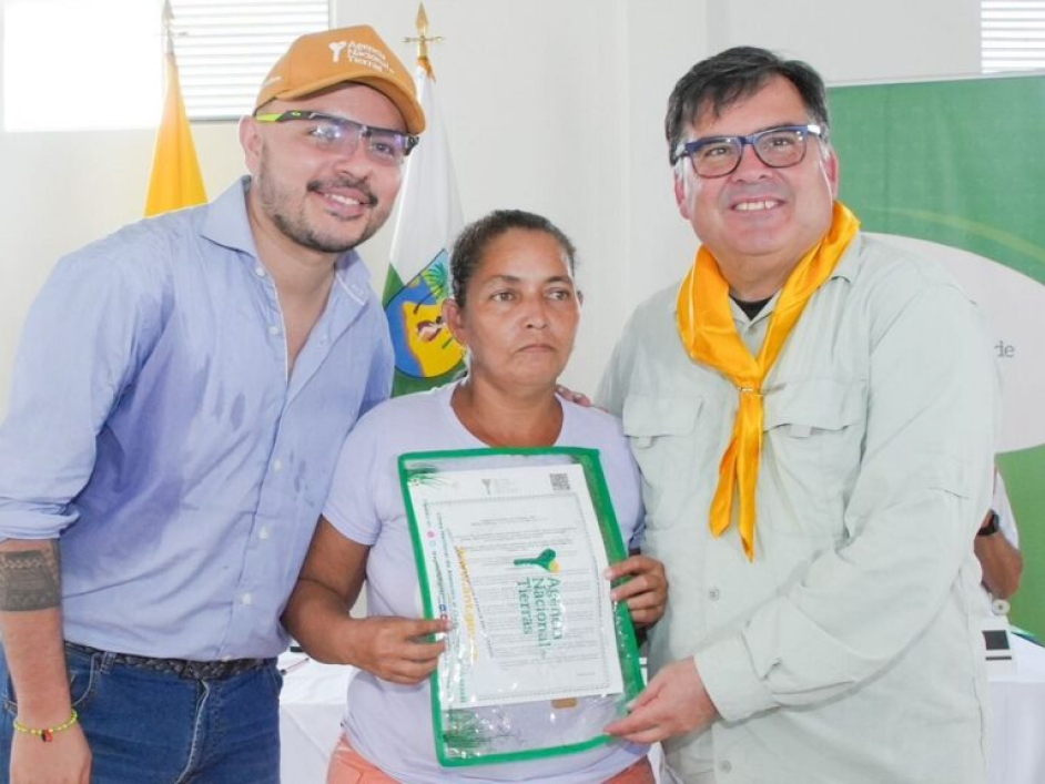 Mujer recibiendo el título de su predio.