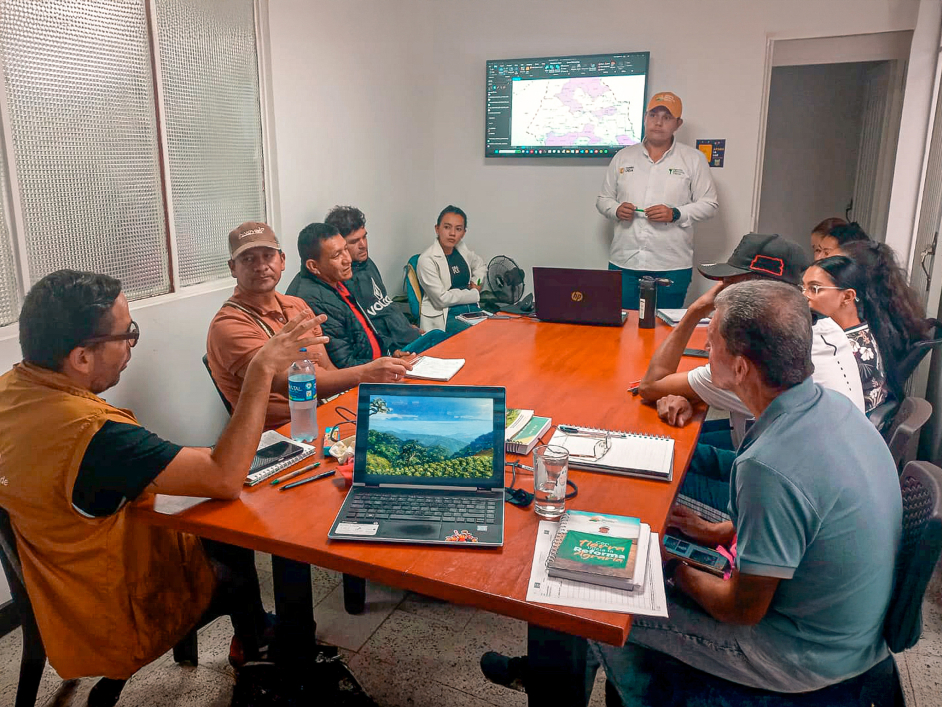 un-grupo-de-personas-sentadas-alrededor-de-una-mesa-con-una-computadora